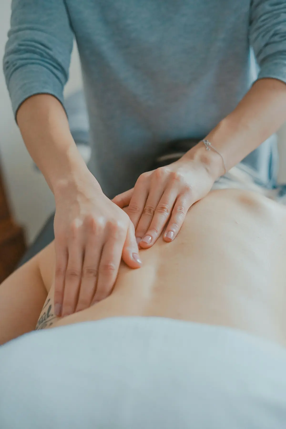 Batu basal hitam hangat yang digunakan untuk hot stone massage diletakkan di punggung klien